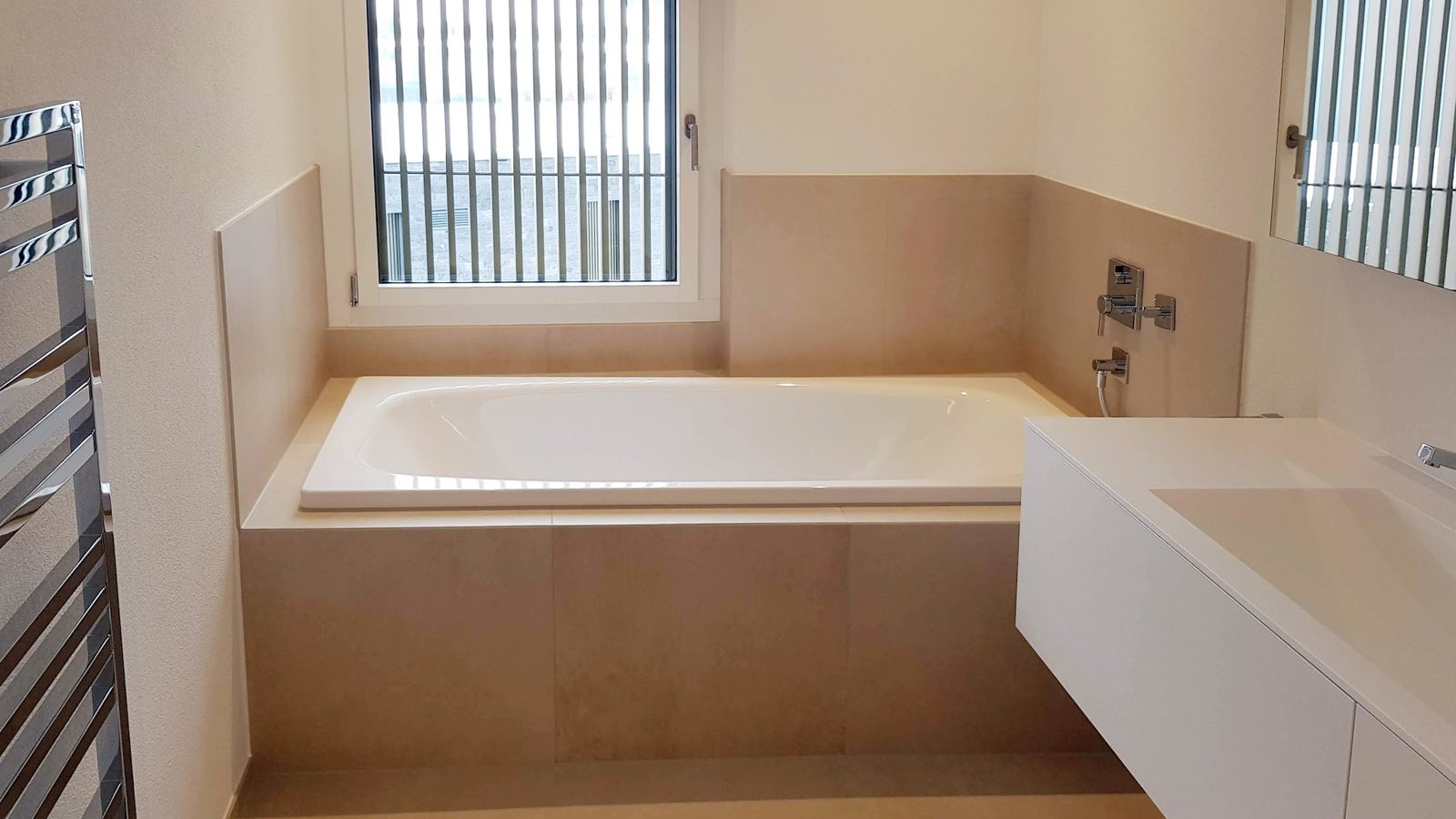 Bad mit eingebauter Wanne und beigen Platten
