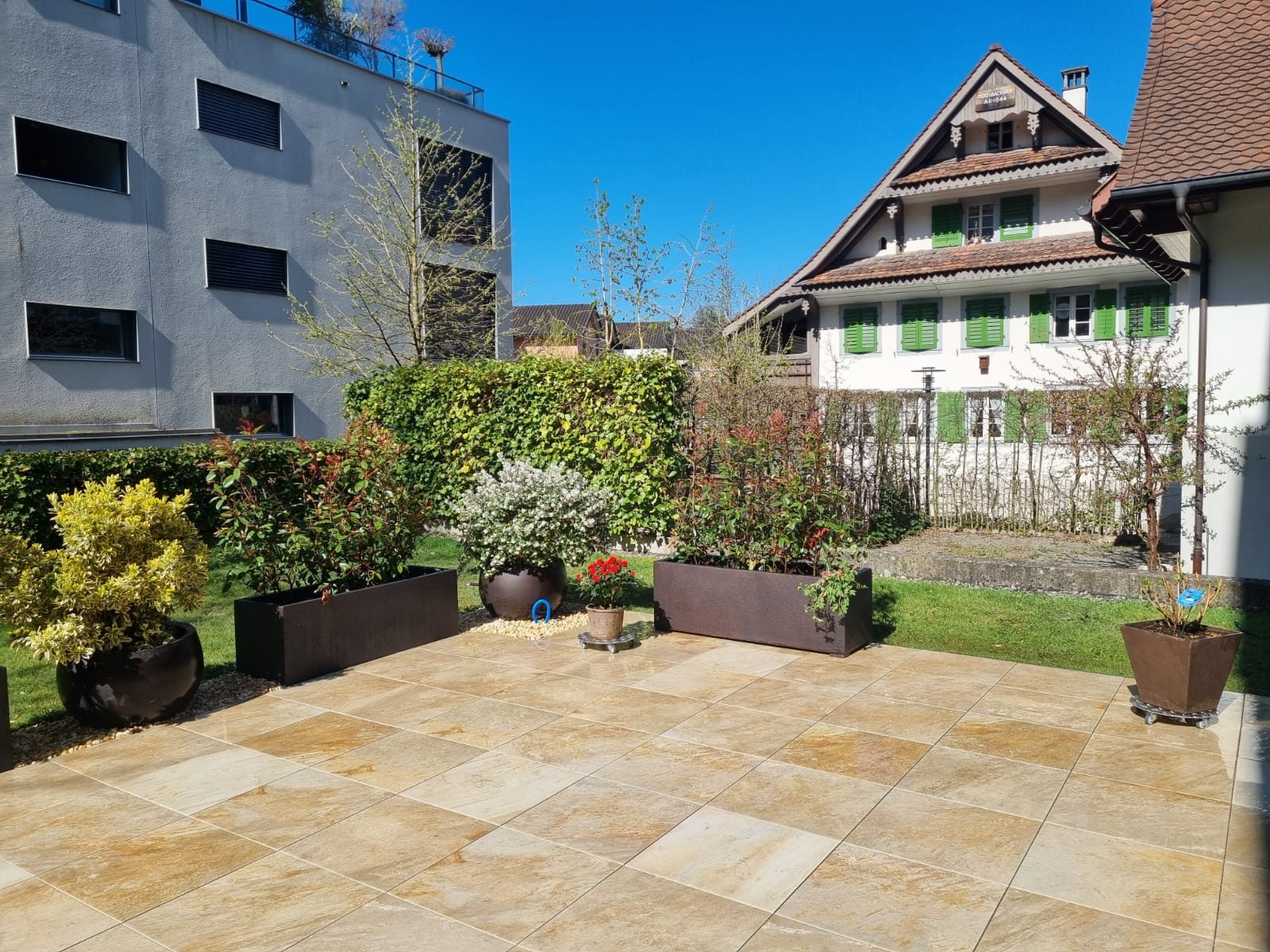Terrasse mit Natursteinplatten vor einem Riegelhaus