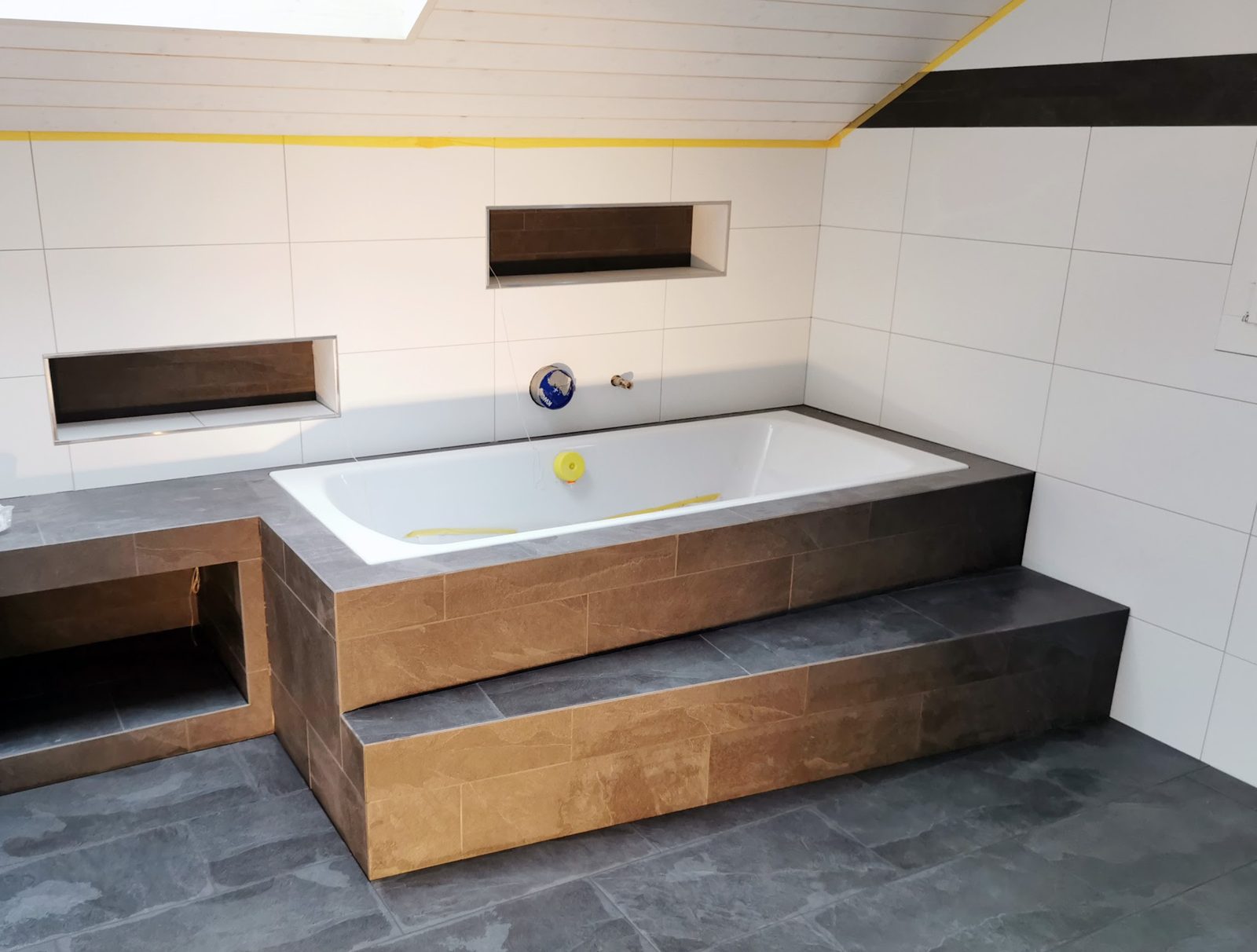 Badewanne mit Plattenverkleidung unter der Dachschräge