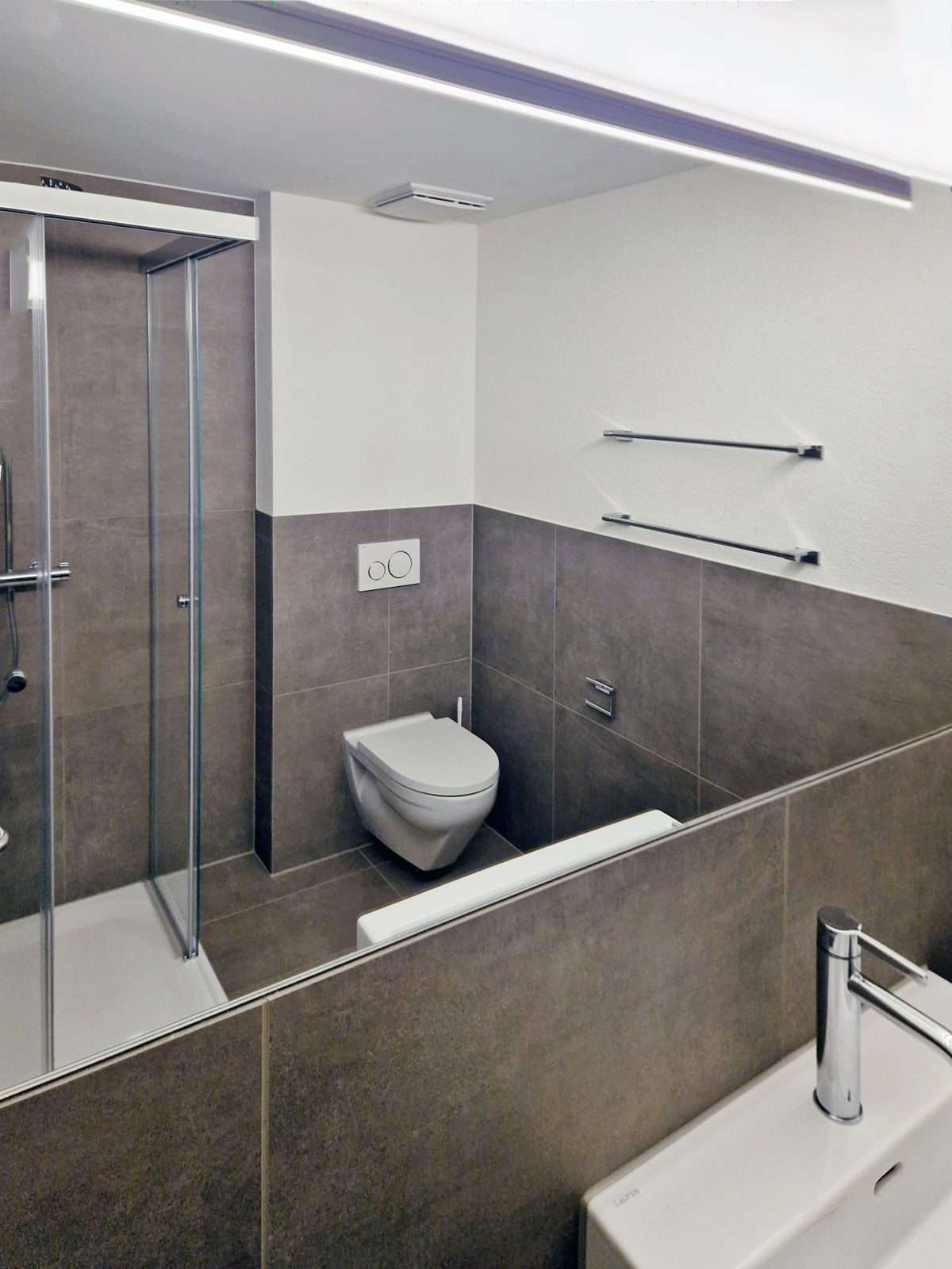 Renoviertes Hotelbadezimmer mit Dusche und WC